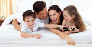 ベッドの上ではしゃぐ家族 大きなベッド